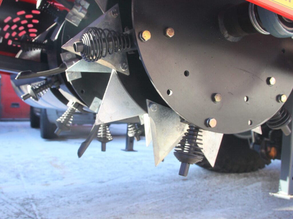 Close-up of a spring-loaded mechanical assembly with coiled springs and metal brackets on a machine surface.