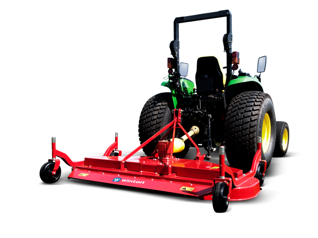 Red mower attachment hitched to a green tractor with large off-road tires on a black background, ready for field work