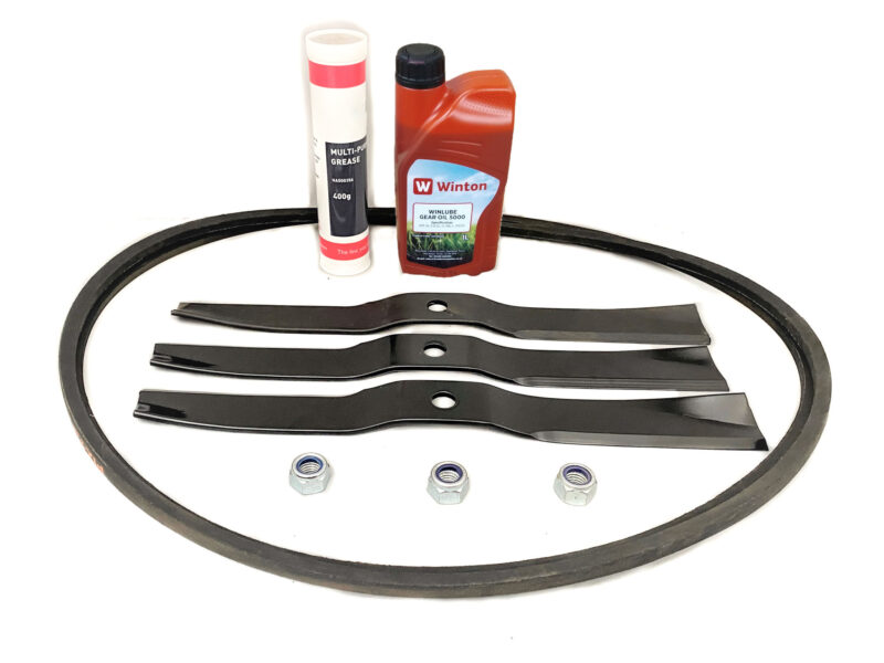 Assorted mower parts: serpentine belt, three blades, spacers, nuts, and a bottle of lubricant with a grease tube in the background.