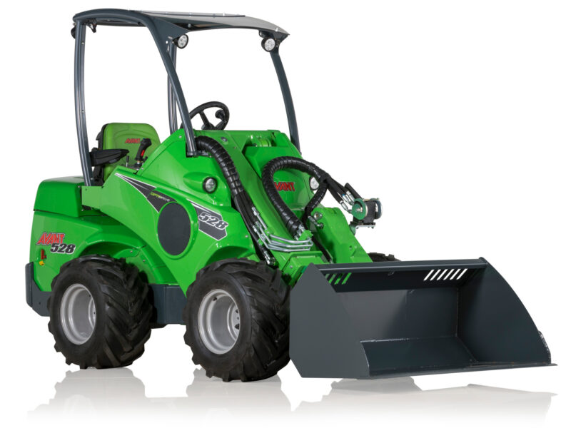 Green compact front-end loader with a large gray bucket in the foreground.