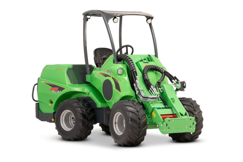 Green compact agricultural loader with a protective roll-over bar, multiple hydraulic hoses, and large off-road tires, viewed from front-left